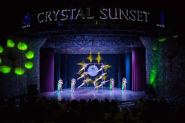 Darbietung im Crystal Sunset Theater mit Akrobaten inmitten von farbigem Licht.