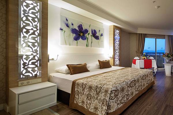 Luxuriöses Hotelzimmer im Crystal Sunset Luxury Resort & Spa mit Doppelbett, Dekor und moderner Einrichtung.
