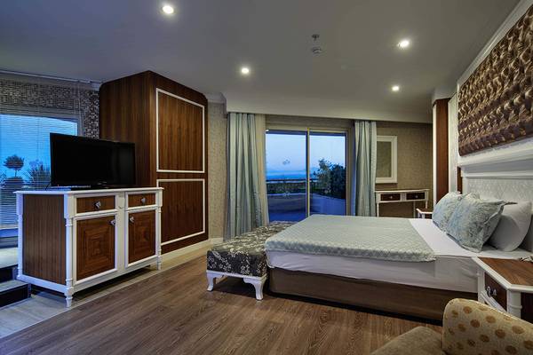 Schlafzimmer im Crystal Sunset Luxury Resort & Spa mit Doppelbett, Fernseher und Aussicht.