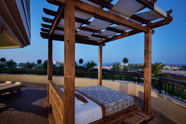 Balkonbett im Crystal Sunset Luxury Resort & Spa mit Blick auf die Stadt
