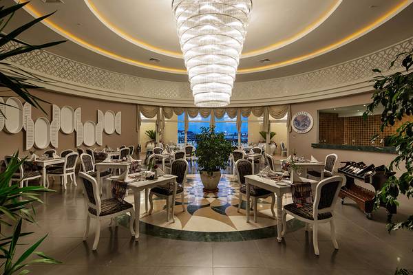 Innenbereich des Crystal Sunset Luxury Resort & Spa mit Restaurant und zentralem Kronleuchter.