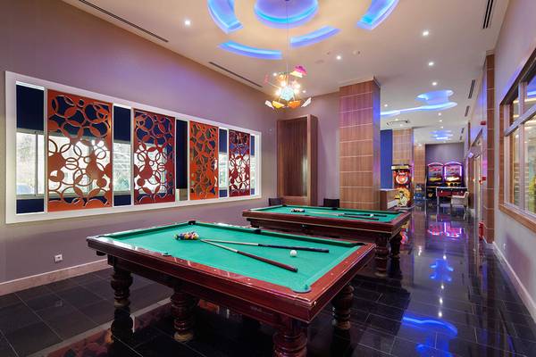 Spielzimmer im Crystal Sunset Luxury Resort & Spa mit zwei Billardtischen und Spielautomaten.