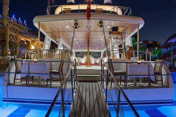 Außenbereich des Crystal Sunset Luxury Resort & Spa mit illuminierten Tischen und Stühlen