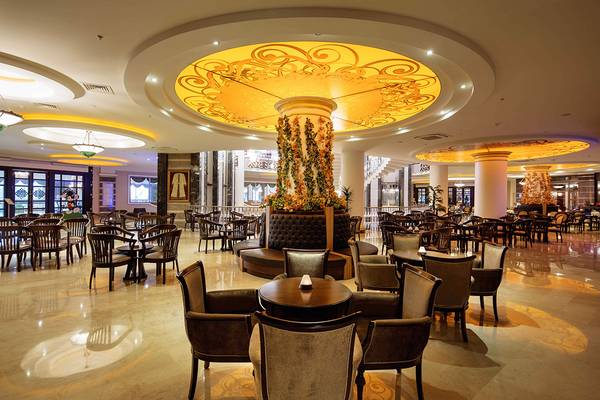 Lobby des Crystal Sunset Luxury Resort & Spa mit runden Tischen und Stühlen.