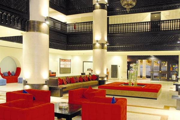 Lobby des Royal Decameron Tafoukt Beach Hotels mit roten Möbeln und hohen Säulen.