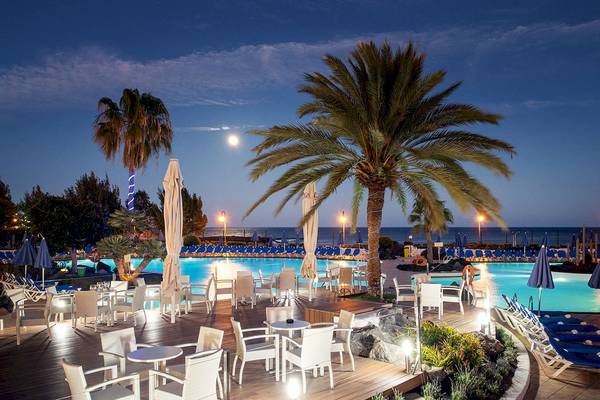 Außenpool des Grand Teguise Playa Hotels bei Nacht mit beleuchteten Tischen und Stühlen