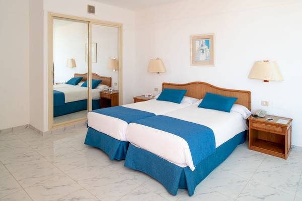 Doppelzimmer im Grand Teguise Playa mit zwei Betten, Spiegel und Nachttischen.
