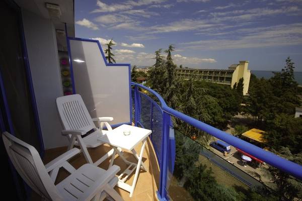 Blick vom Balkon des Aphrodite Hotel Golden Sands mit zwei weißen Stühlen, einem Tisch und einer Aussicht auf das Meer.