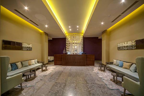 Lobby des Ancient Sands Golf Resorts mit Couchen, Tischen und Beleuchtung