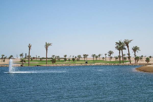 Golfplatz mit Wasserhindernis und Palmen am Ancient Sands Golf Resort