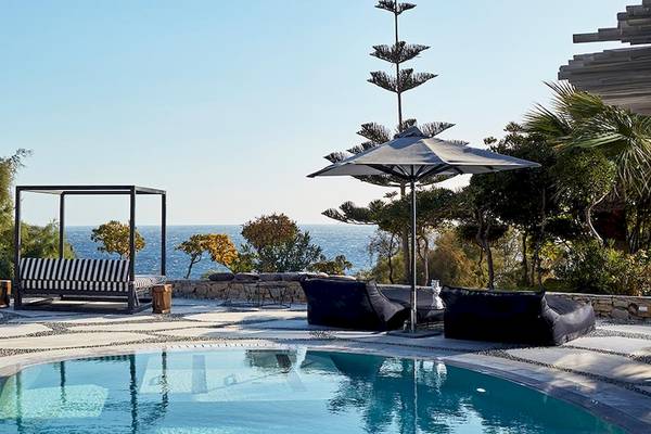 Poolbereich im Myconian Imperial - Leading Hotels of the World mit Meerblick und Loungemöbeln.