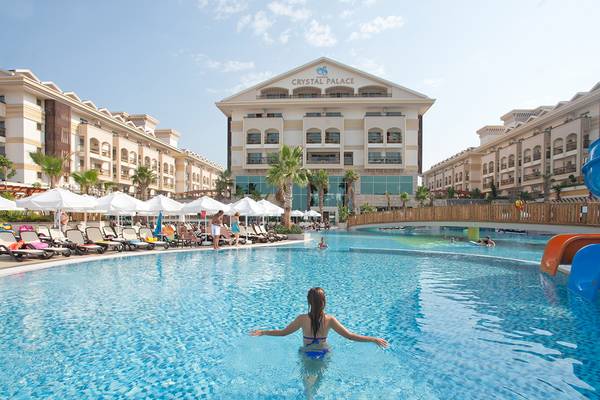 Eine Frau schwimmt in einem Pool vor dem Crystal Palace Hotel.