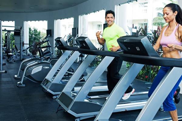 Mann und Frau trainieren auf Laufbändern im Fitnessstudio des Grand Palladium Jamaica.