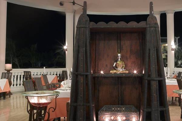 Innenbereich des Grand Palladium Jamaica R. & Spa Hotels mit Buddha-Statue und illuminierten Tischen.