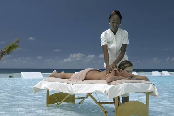 Frau genießt eine Massage am Pool im Grand Palladium Jamaica