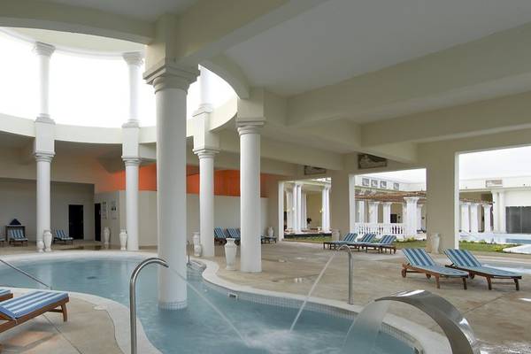 Innenbereich des Grand Palladium Jamaica R. & Spa mit Swimmingpool und Säulen.