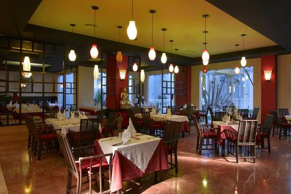 Restaurant im Grand Palladium Jamaica R. & Spa mit gedeckten Tischen und dekorativen Lampen.