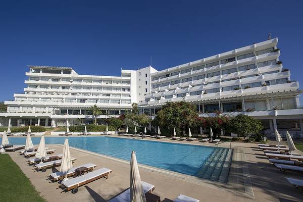 Außenansicht des Grecian Sands Hotels mit Swimmingpool und Sonnenliegen.