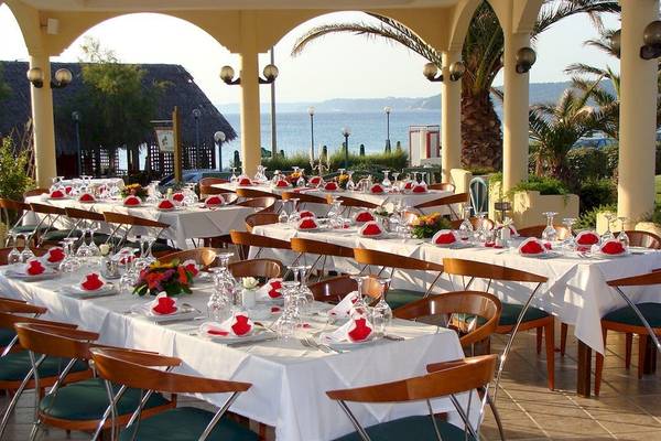 Restaurantbereich des Possidi Holidays Resort & Suites mit mehreren gedeckten Tischen.