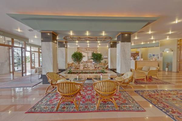 Lobby des Possidi Holidays Resort & Suites mit Sitzgelegenheiten und Pflanzen.