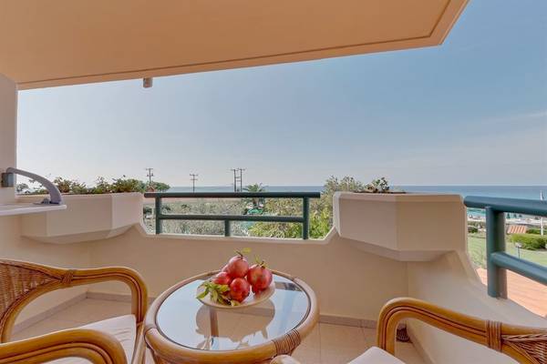 Balkon des Possidi Holidays Resort & Suites mit Blick auf das Meer und Früchten auf dem Tisch.