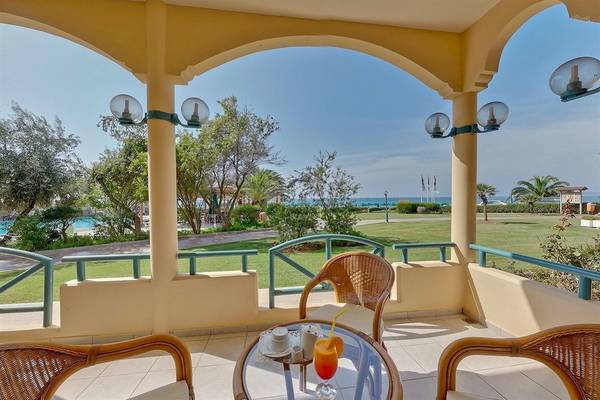Terrasse des Possidi Holidays Resort & Suites mit Blick auf das Meer.