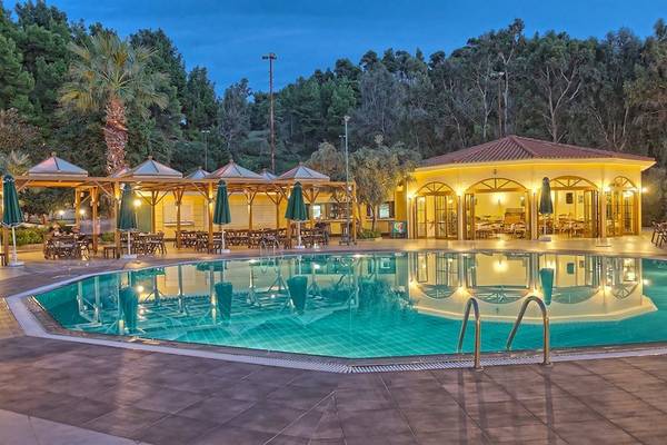 Außenbereich des Possidi Holidays Resort & Suites mit Swimmingpool und Loungebereichen.