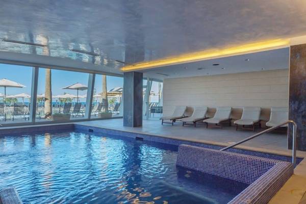 Poolbereich im Aparthotel Fontanellas Playa mit Loungestühlen und Meerblick