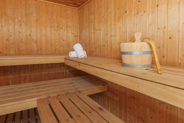 Innenansicht der Sauna im Aparthotel Fontanellas Playa mit Holzbänken und Handtuch