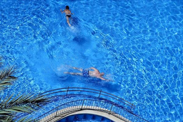 Zwei Leute schwimmen im Pool vom Cosmopolitan Hotel, eine Frau oben und ein Mann unten.
