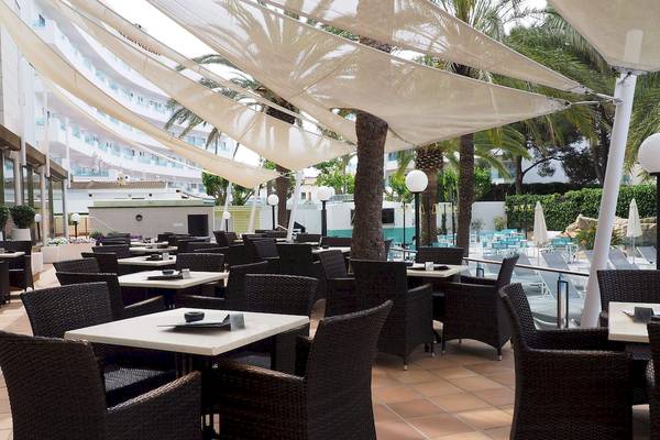 Außenbereich des Cosmopolitan Hotels mit Tisch und Stuhl-Arrangement unter weißen Sonnensegel.