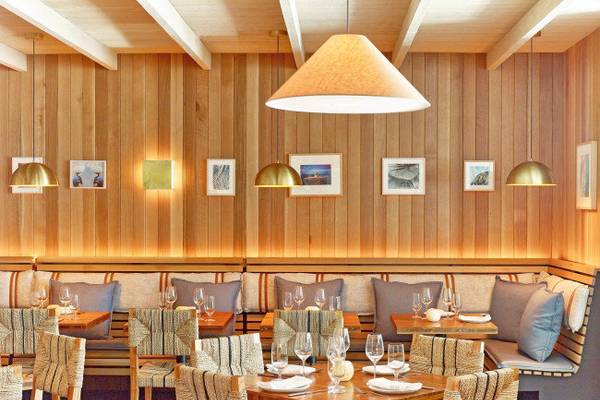 Innenansicht des Restaurants im 1 Hotel South Beach mit hölzernen Wänden, Sitzgelegenheiten und Tischen.