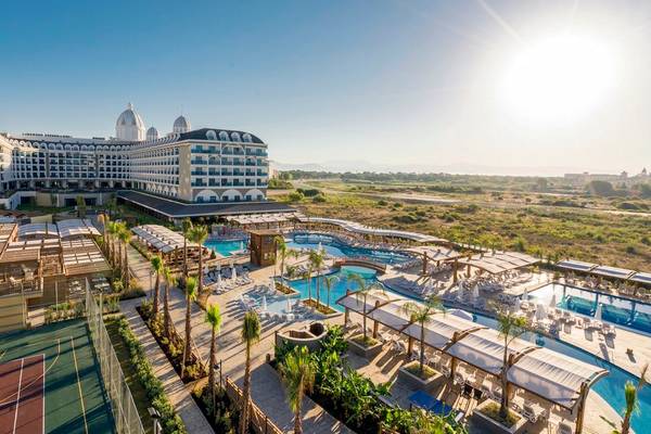 Außenansicht des Adalya Elite Lara Hotels mit Swimmingpool und Tennisplatz.