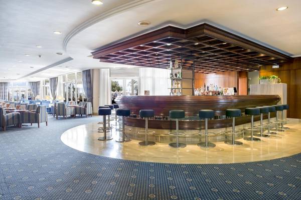 Barbereich des Hipotels Flamenco Hotels mit Holztheke und Barhockern.