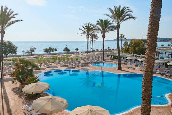 Außenpool und Sonnenliegen des Hipotels Flamenco mit Blick auf das Meer