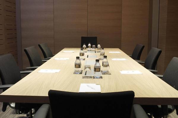 Ein Konferenzraum im Hotel Barcelona Catedral mit einer langen Tabelle und leeren Stühlen.