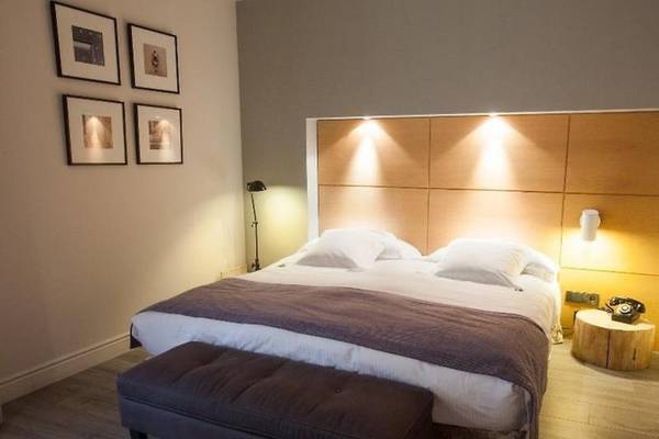 Schlafzimmer im Hotel Barcelona Catedral mit Doppelbett, Nachttisch und Bildern an der Wand.