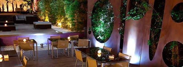 Terrasse des Barcelona Catedral Hotels mit Tischen, Stühlen und Pflanzenwänden