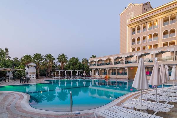 Außenpool des Sultan of Side Hotels mit weißen Sonnenliegen und Sonnenschirmen.