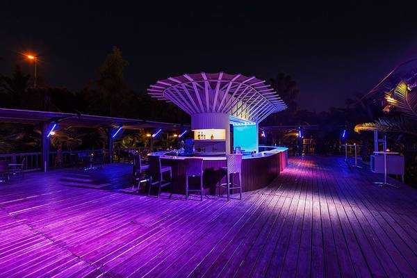 Barbereich des Sultan of Side Hotels bei Nacht mit lila Beleuchtung und Lounge-Stuhl