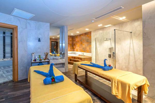 Massageraum im Sidemarin Kirman Premium Hotel mit zwei Liegen und blauen Handtüchern.