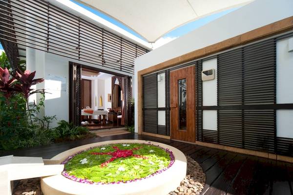 Außenbereich des JW Marriott Khao Lak Resort & Spa mit einem Blumenbeet und offenen Türen.