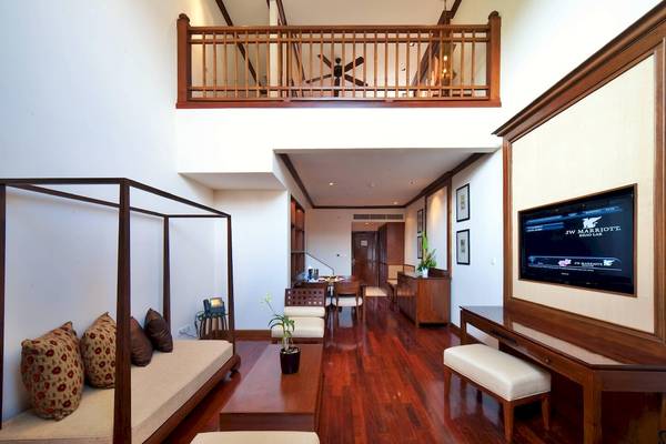 Inneneinrichtung einer Suite im JW Marriott Khao Lak Resort & Spa mit modernem Möbeldesign und Holzboden.