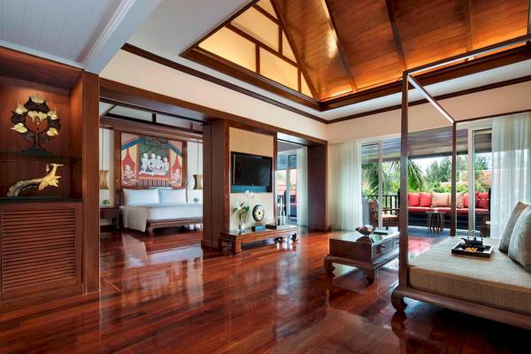Innenansicht der Suite im JW Marriott Khao Lak Resort & Spa mit Holzboden, großem Bett und offenem Balkon.