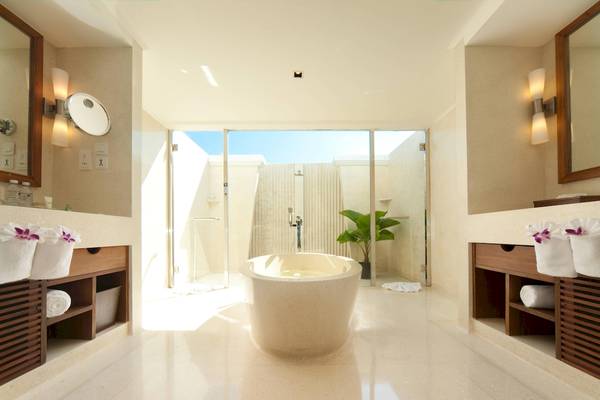 Badezimmer mit freistehender Badewanne und Zugang zum Außenbereich.