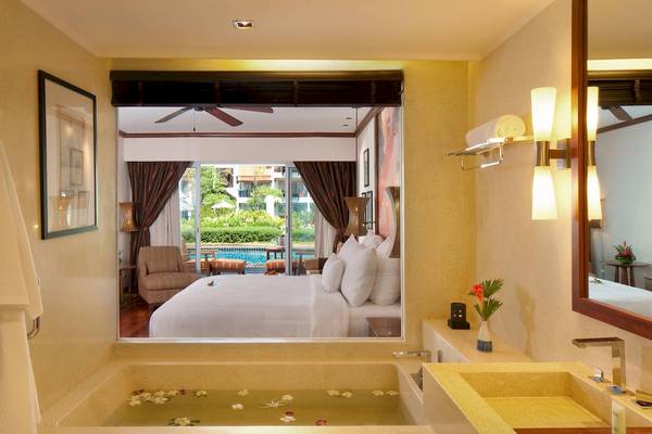 Badezimmer mit Ausblick auf das Bett und den Pool im JW Marriott Khao Lak Resort & Spa.