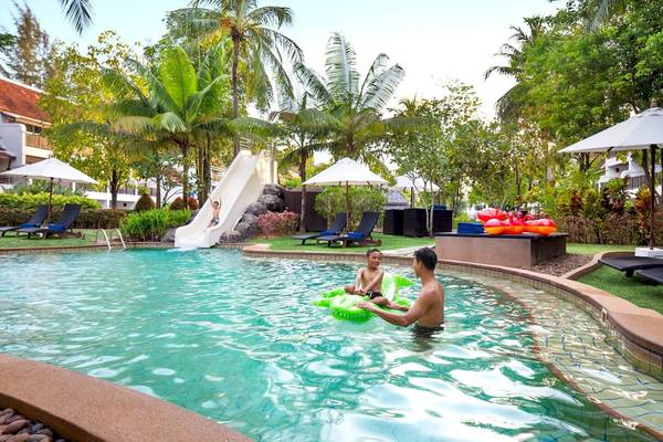 Familie am JW Marriott Khao Lak Resort Pool, Kind rutscht und Vater hilft