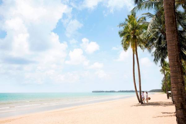 Strand des JW Marriott Khao Lak Resort mit zwei Paaren, die spazieren gehen.