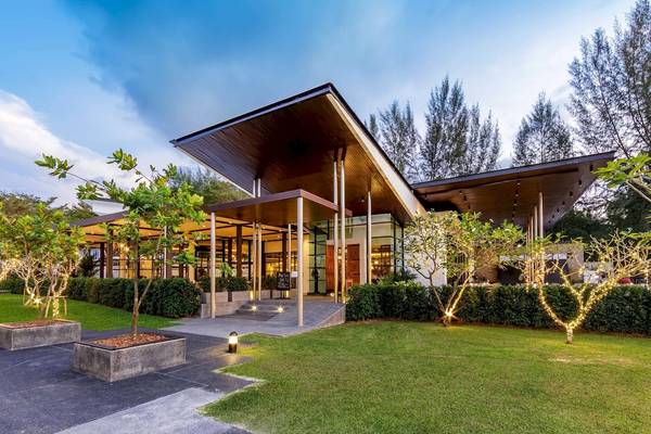 Außenansicht des JW Marriott Khao Lak Resorts mit Beleuchtung und gepflanzten Bäumen.