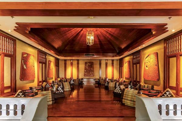 Loungebereich des JW Marriott Khao Lak Resort & Spa mit Holzboden und Kunstwerken an den Wänden.